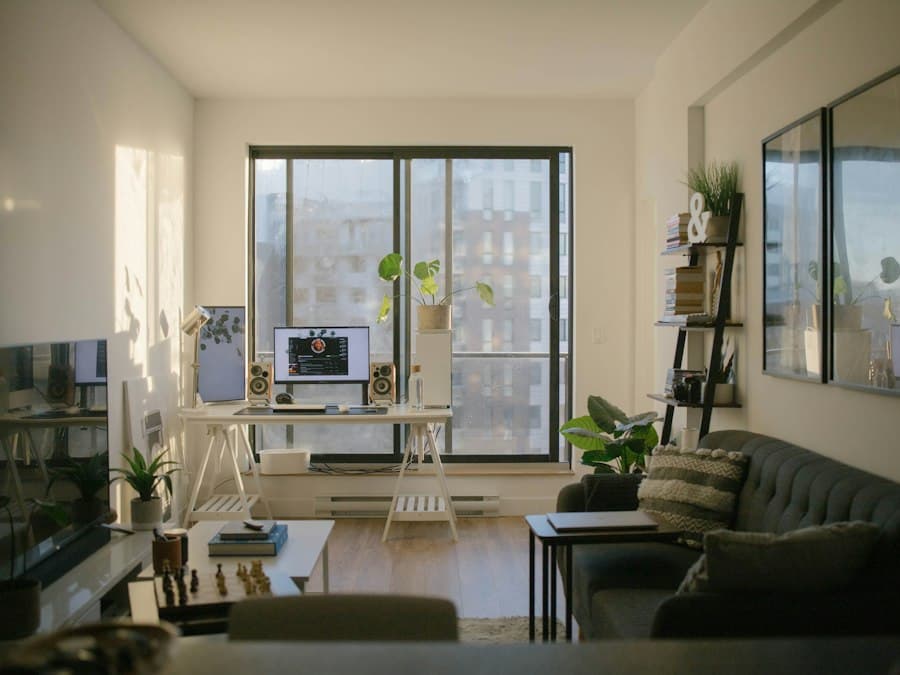 Wohnzimmer mit Sofa und Schreibtisch vor einem großen Fenster
